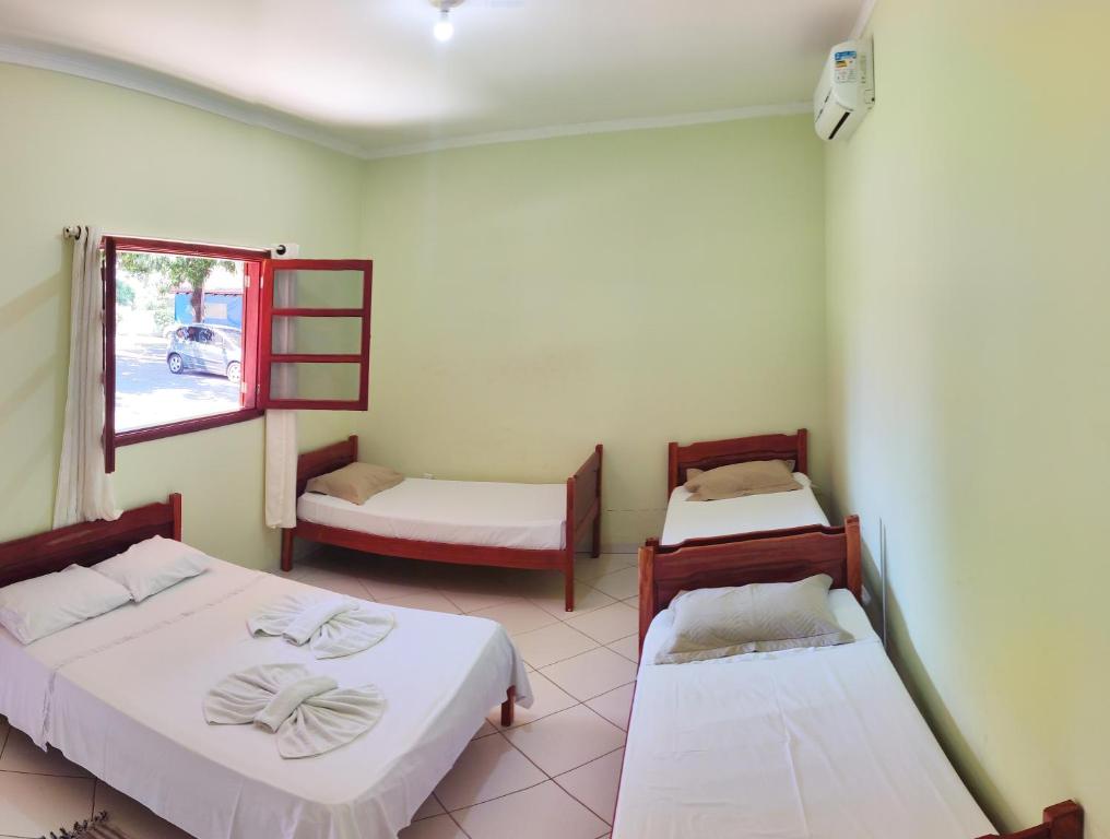 a room with two beds and a window at Pousada Voo das Garças in Bonito