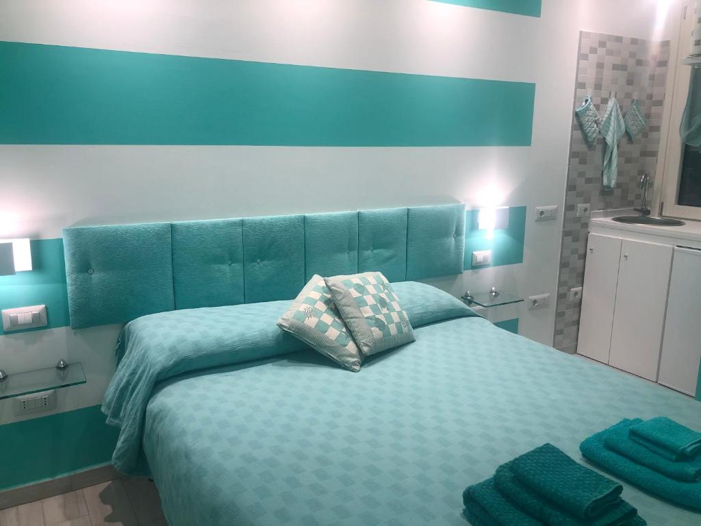 Schlafzimmer mit einem Bett mit blauem Kopfteil in der Unterkunft IL TURCHESE in Cagliari