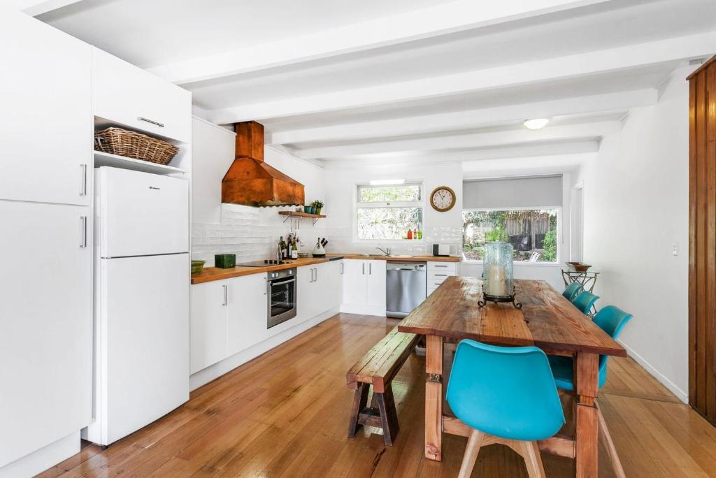 a kitchen with a wooden table and blue chairs at Idyllic Ingram in Anglesea