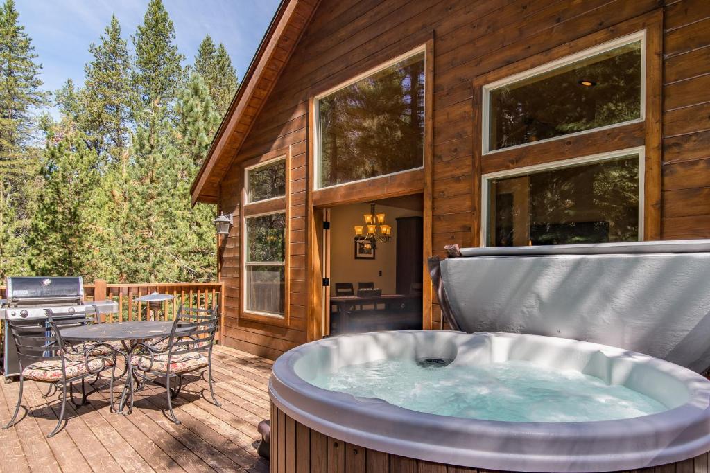 a hot tub on a deck with a table and chairs at Serenity at Northwoods in Truckee