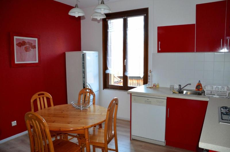 cocina con mesa de madera y cocina con paredes rojas en Chez Laurence et Claude - Vallée de Munster, en Luttenbach-près-Munster