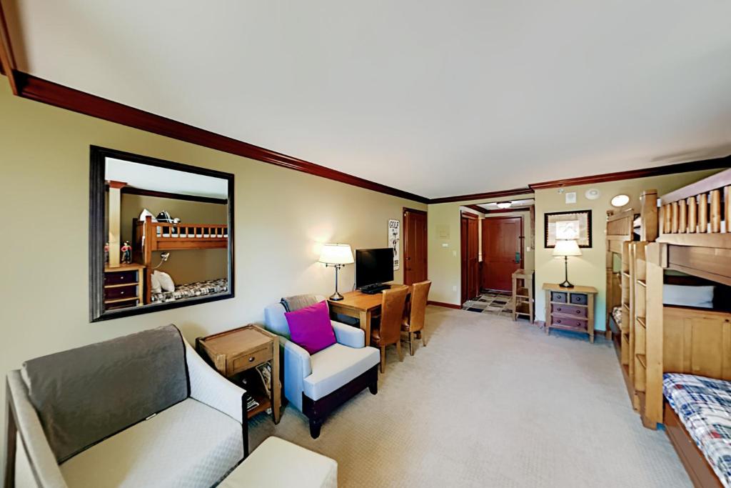 a living room with a couch and a dining room at Resort at Squaw Creek's 126 in Olympic Valley