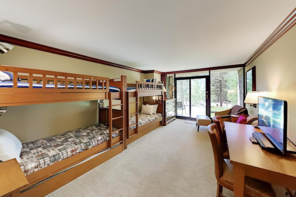 a room with two bunk beds and a desk and a desk at Resort at Squaw Creek's 126 in Olympic Valley