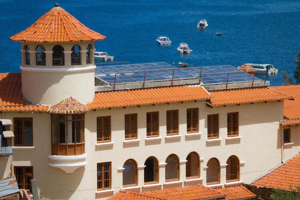 ein Gebäude mit einem Leuchtturm auf dem Meer in der Unterkunft Hotel Rosario Lago Titicaca in Copacabana