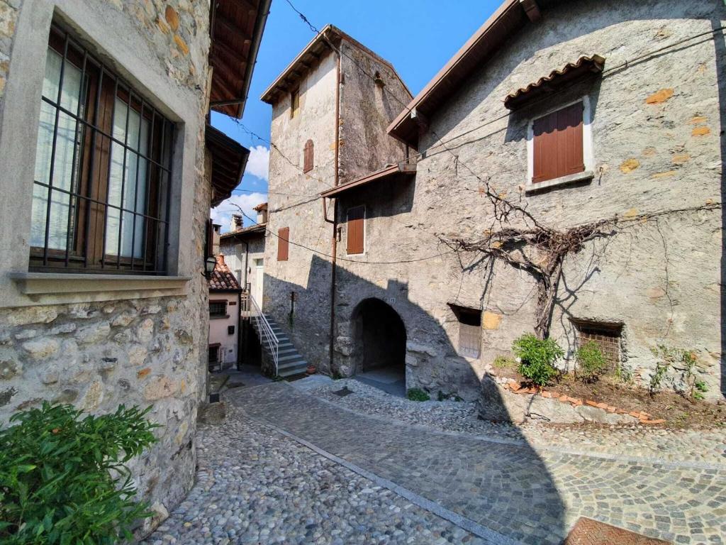 un callejón en un antiguo edificio de piedra con una torre en Pleasant holiday home in Marone with balcony terrace, en Marone