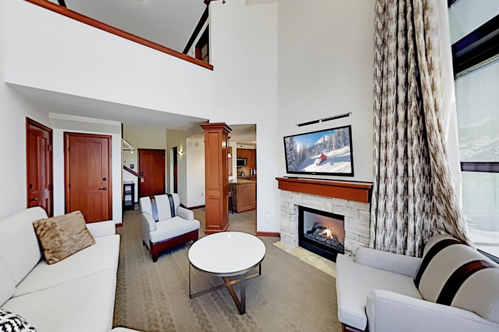 a living room with white furniture and a fireplace at Resort at Squaw Creek's 810 & 812 in Olympic Valley