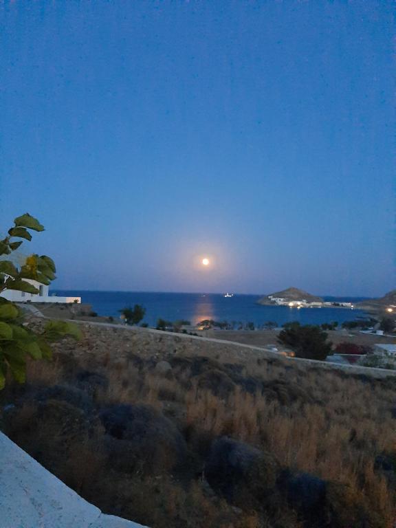 Una luna elevándose sobre el océano por la noche en Chaniotis Studios, en Kalafatis