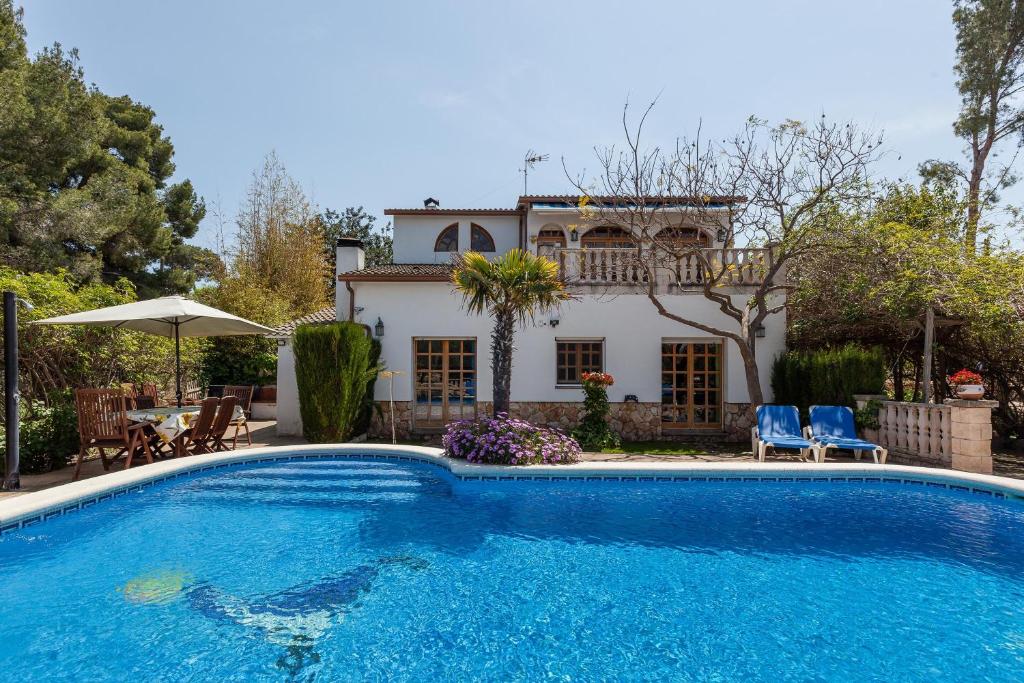 una grande piscina di fronte a una casa di Villa Gessami a Barcellona