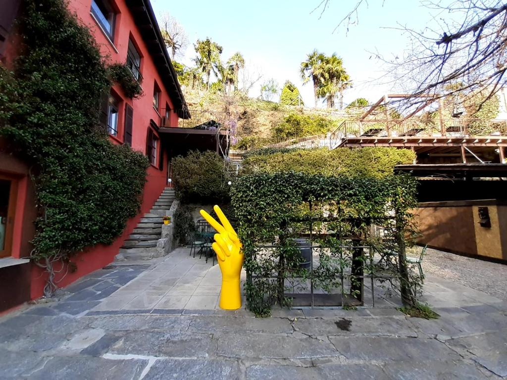 un idrante giallo per il fuoco seduto accanto a un edificio di La casa di Arnaldo La cuccia ad Agno