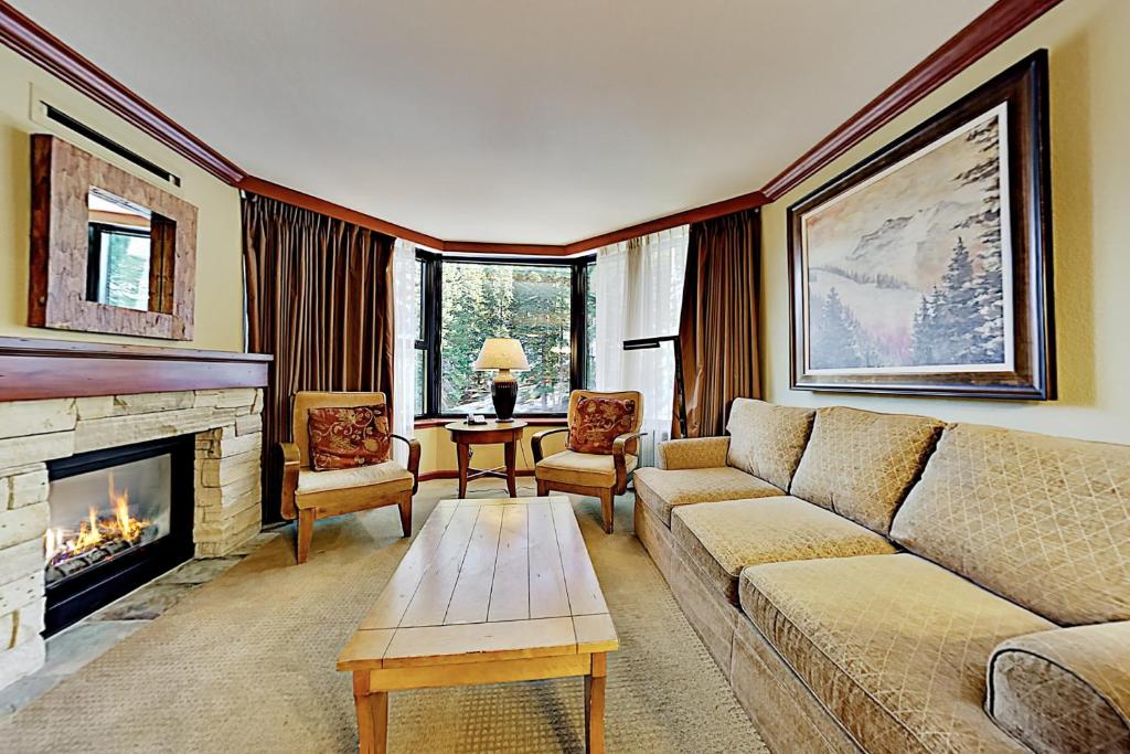 a living room with a couch and a fireplace at Resort at Squaw Creek's 605 & 607 in Olympic Valley