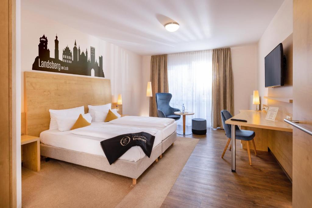 ein Hotelzimmer mit einem Bett und einem Schreibtisch in der Unterkunft Landhotel Endhart in Landsberg am Lech