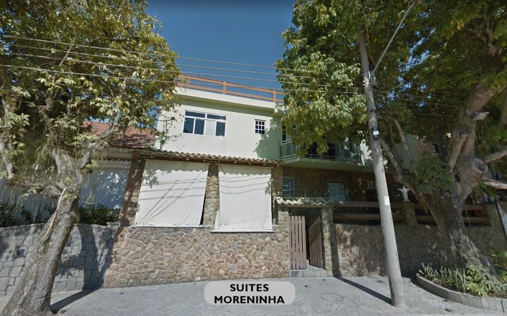 a house with white curtains in front of it at Suites Moreninha in Rio de Janeiro