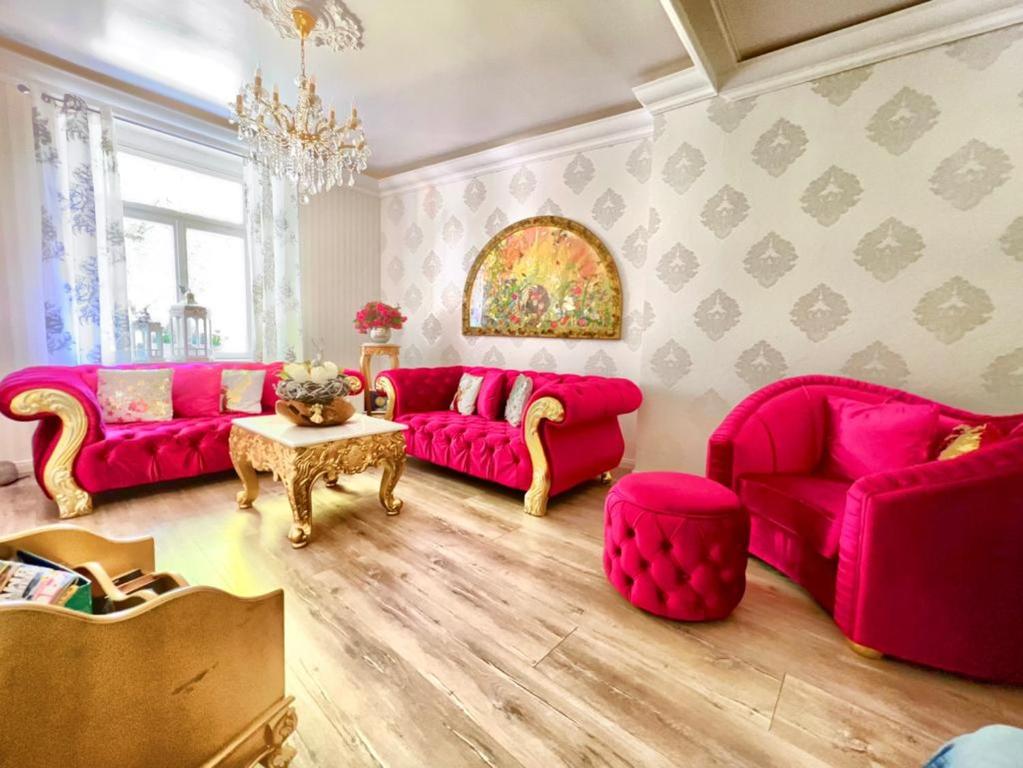 Boutiquehotel Villa Rosenhof في بادينوييلر: غرفة معيشة مع كنب وردي وطاولة