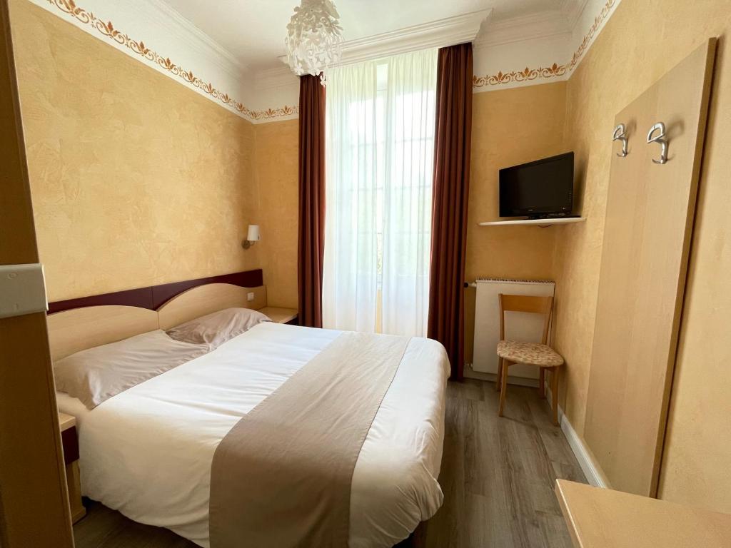 une chambre d'hôtel avec un lit et une télévision dans l'établissement Le Mirval, à La Brigue