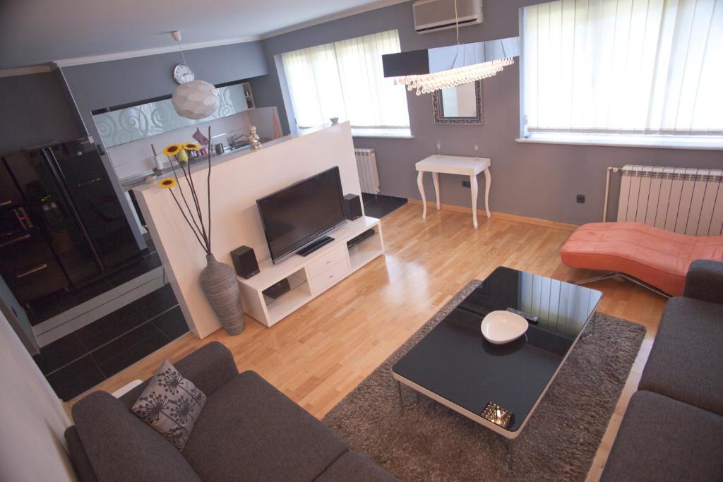 - un salon avec un canapé et une télévision dans l'établissement Angel Apartment, à Belgrade