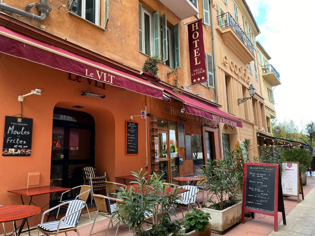 restauracja ze stołami i krzesłami poza budynkiem w obiekcie Hotel Villa La Tour w Nicei