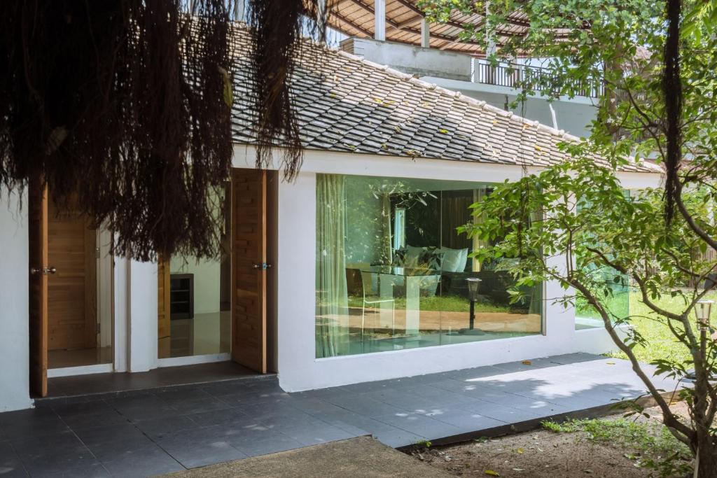 a glass extension to a house with a garden at 4U Resort Samui in Lamai