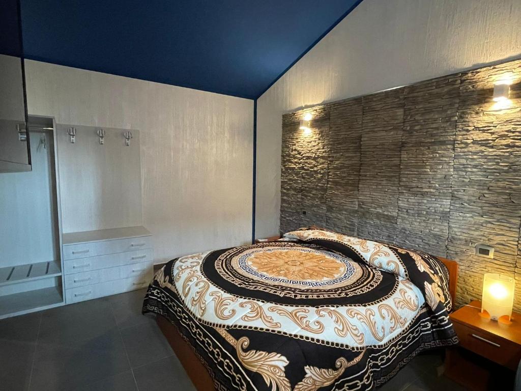 Schlafzimmer mit einem Bett mit gemusterter Decke in der Unterkunft Beach apartments in Campomarino