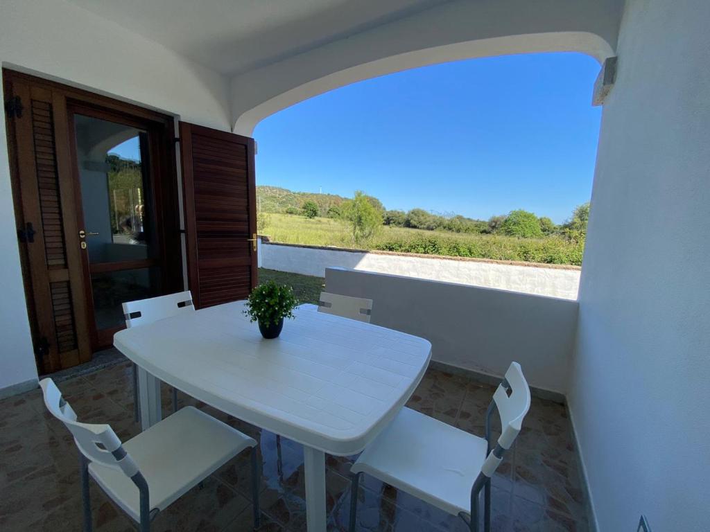 een witte tafel en stoelen op een balkon met uitzicht bij Casa Relax - Sas Murtas Posada in San Lorenzo