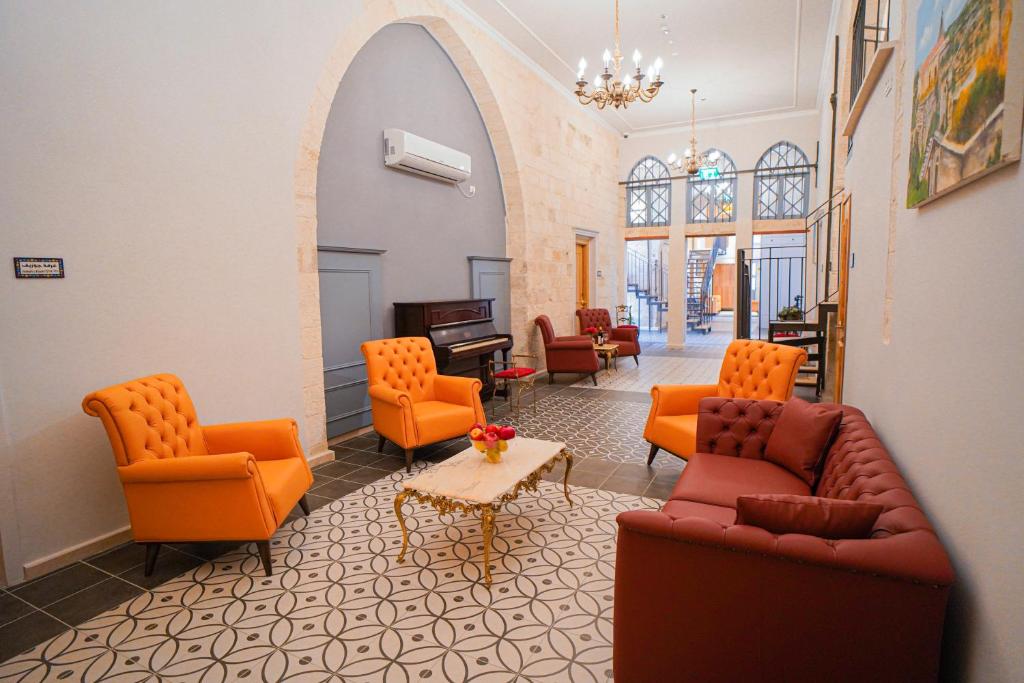 a living room with orange chairs and a table at Michel House in Nazareth