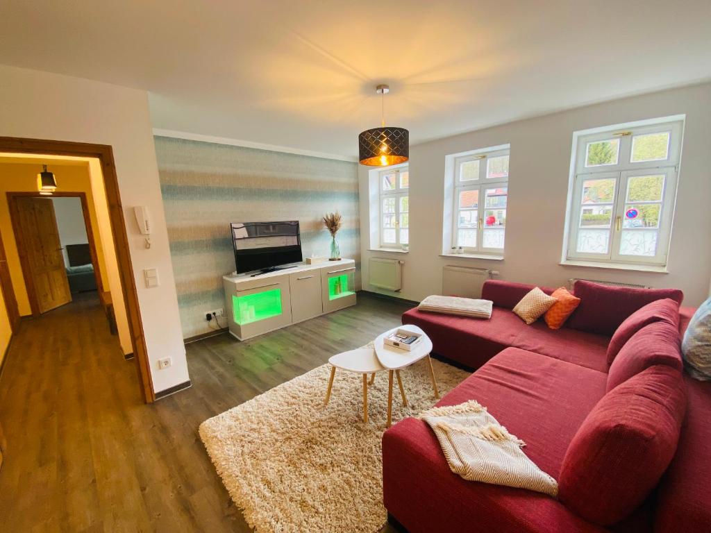 een woonkamer met een rode bank en een tv bij Fewo Heinrichser Markt - 2 Schlafzimmer mit Sauna und Terrasse in Suhl