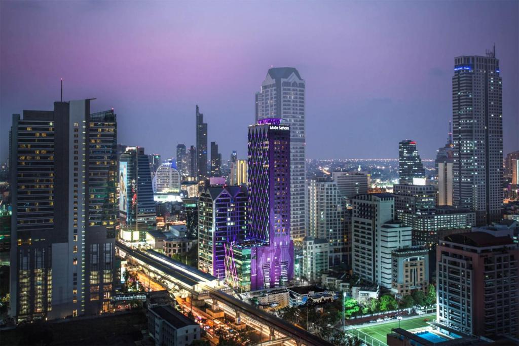 uma cidade iluminada à noite com muitos edifícios altos em Mode Sathorn Hotel - SHA Extra Plus em Banguecoque