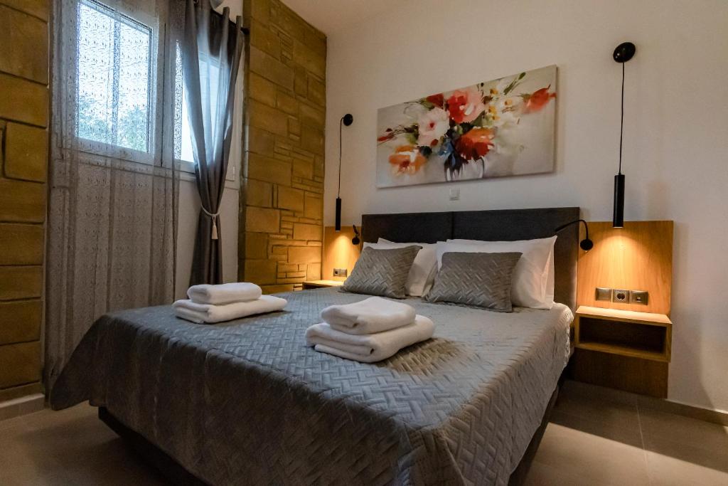 a bedroom with a bed with two towels on it at Rikanthos Stone Sea View Apartment in Falelianá