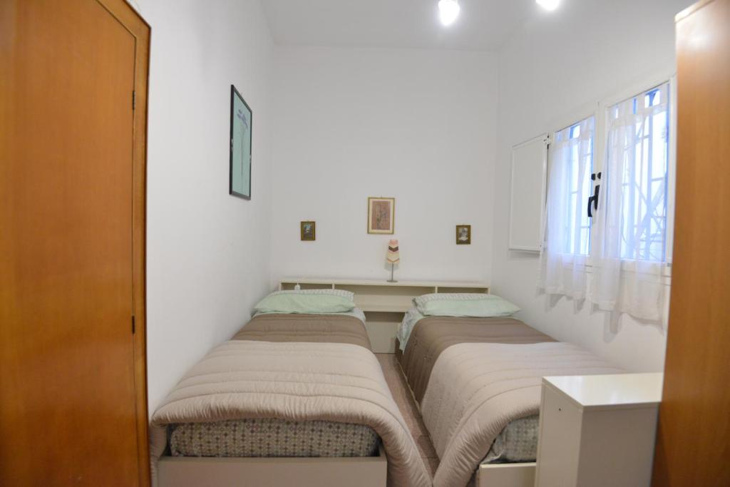 two beds in a room with white walls and a window at B&B CASAVACANZE CHIESA MADRE in Carovigno