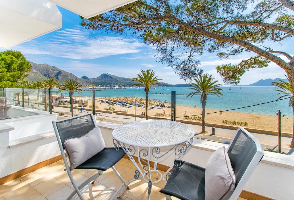 uma varanda com mesa e cadeiras e vista para a praia em Apartment Ran de Mar em Port de Pollença