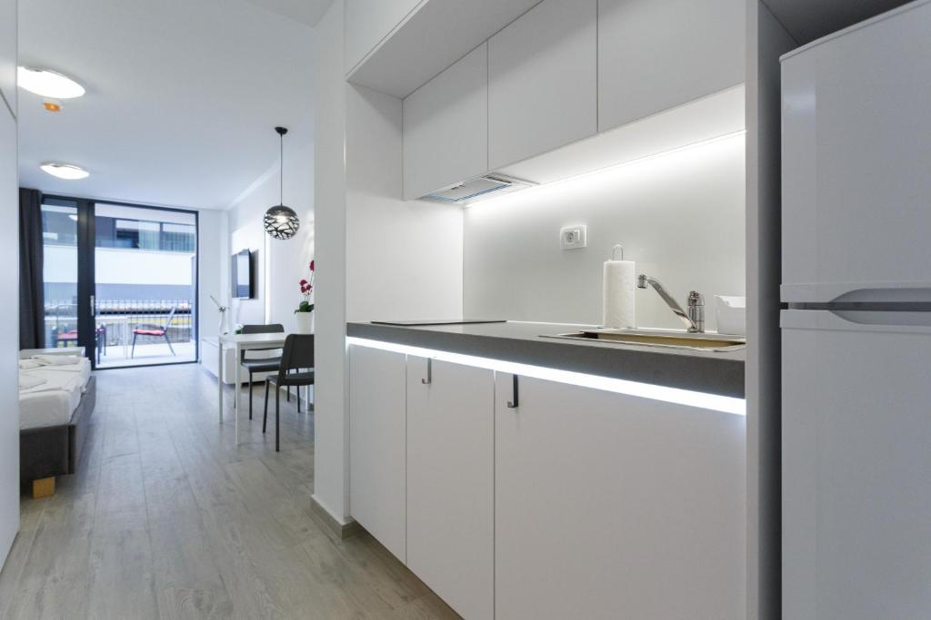 cocina blanca con fregadero y comedor en Apartments Sindy and Mendy with parking space in the garage, en Dubrovnik