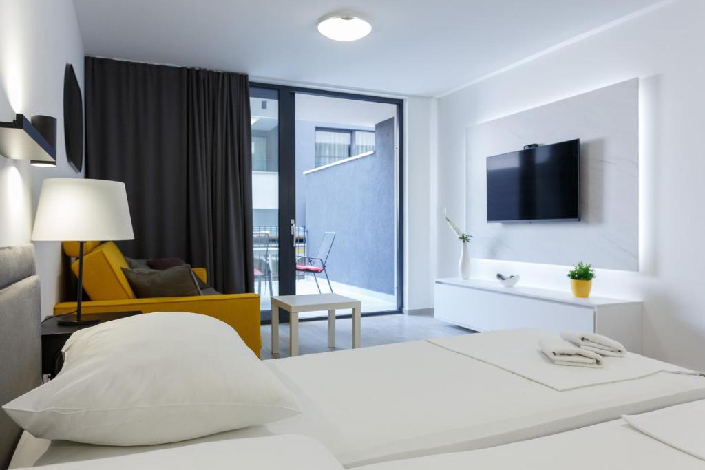 1 dormitorio blanco con 1 cama y TV en Apartments Sindy and Mendy with parking space in the garage en Dubrovnik