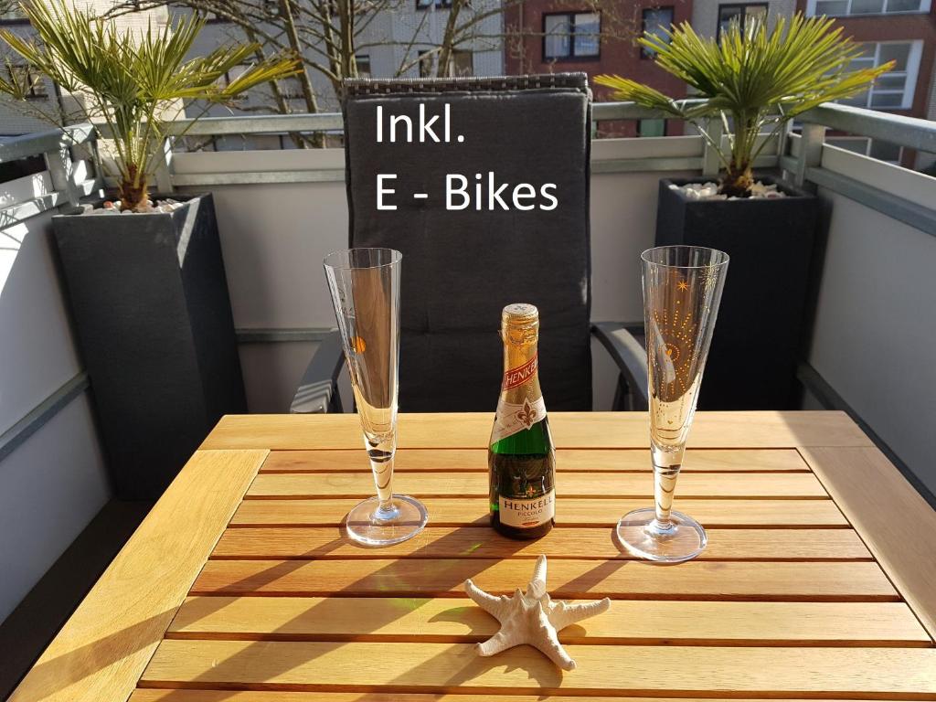 Una botella de champán y dos copas en una mesa. en kleiner Seestern, en Cuxhaven