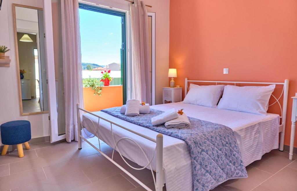 een slaapkamer met een bed en een groot raam bij Vicky’s Luxury Apartment Sidari in Sidari
