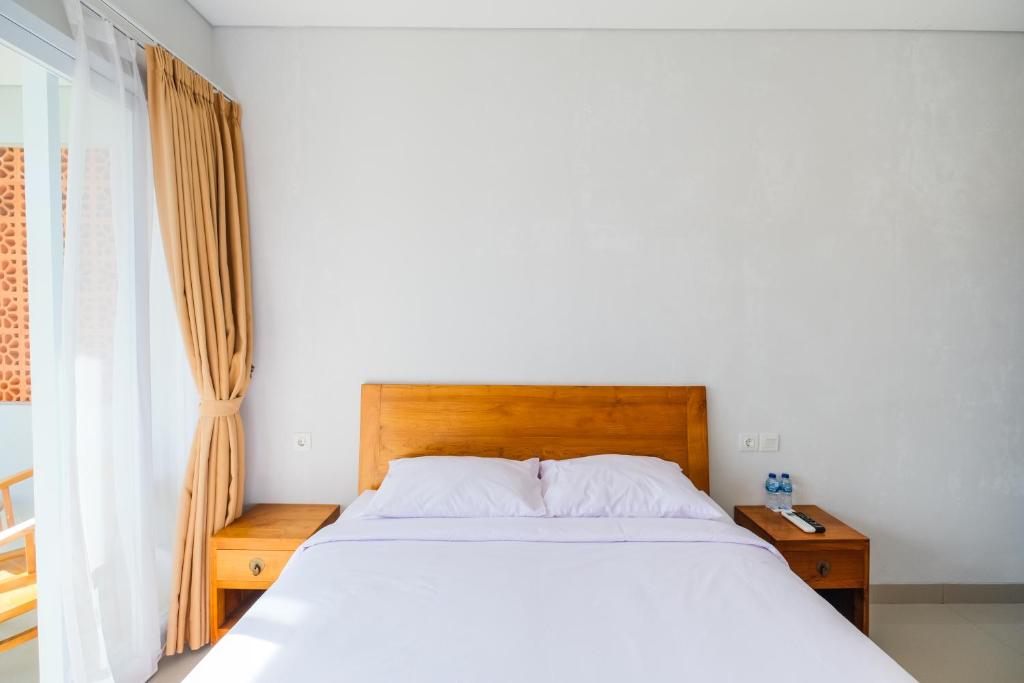 Postel nebo postele na pokoji v ubytování Dharma Guest House Seminyak RedPartner