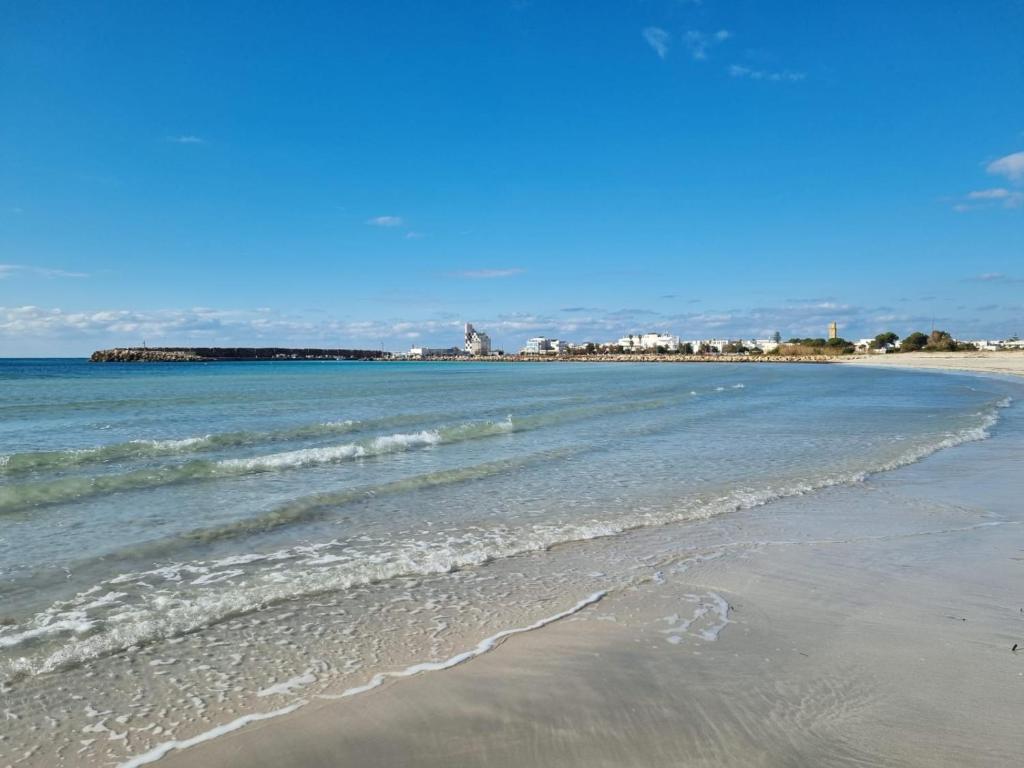 トッレ・サン・ジョヴァンニ・ウジェントにあるFronte Mareの海と建物を背景に広がるビーチ