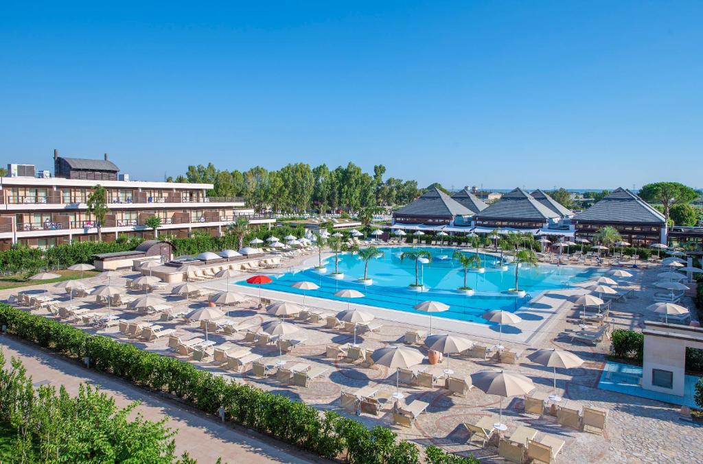 vista aerea su un resort con piscina e sedie di Ethra Reserve Valentino a Castellaneta Marina