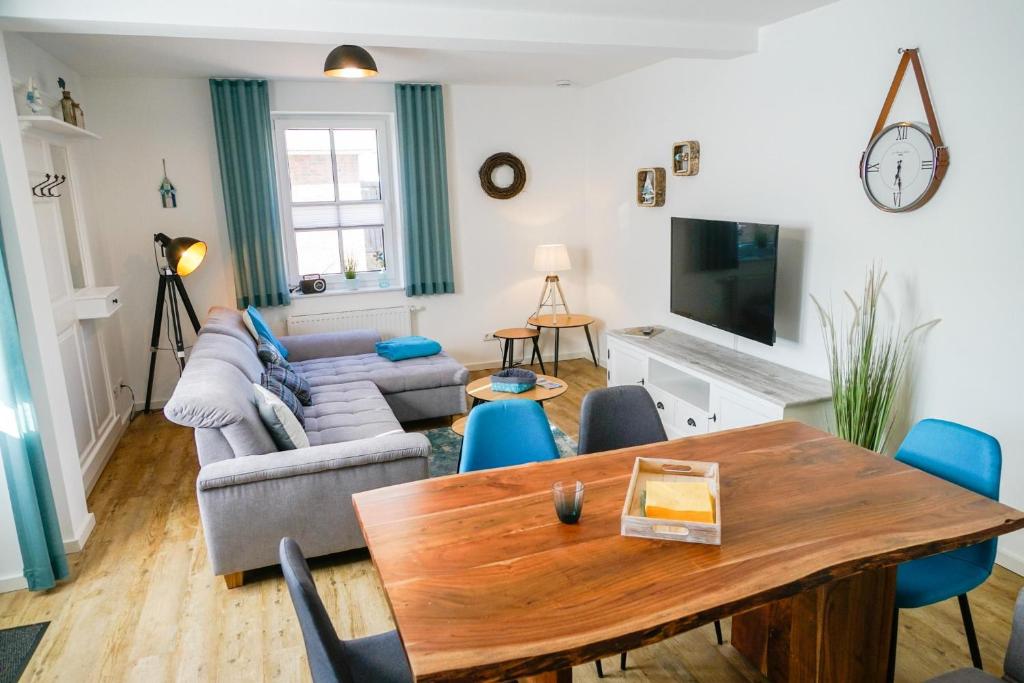 a living room with a table and a couch at Ferienwohnung 4 "Gut Tossens" in Butjadingen OT Tossens