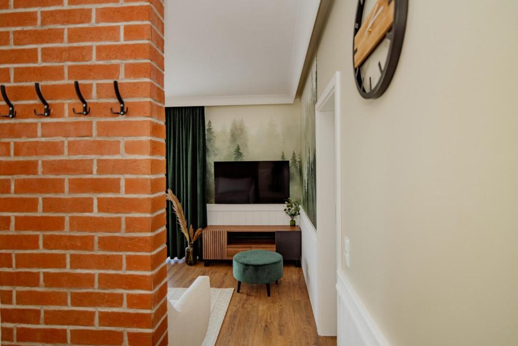ściana z cegły oddziela korytarz od salonu w obiekcie Apartament Forest w Łagowie