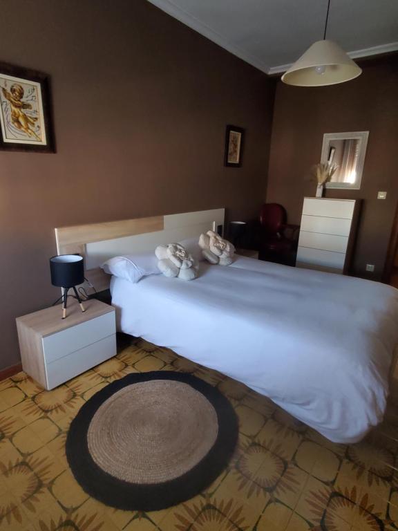 a bedroom with a bed with two stuffed animals on it at Rioja Martín in Alba de Tormes