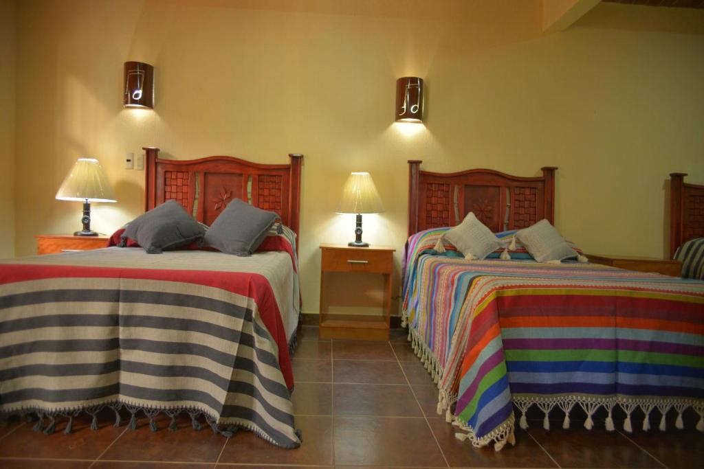 a bedroom with two beds and two lamps at OYO Hotel Castillo Santa Cecilia in Tapalpa