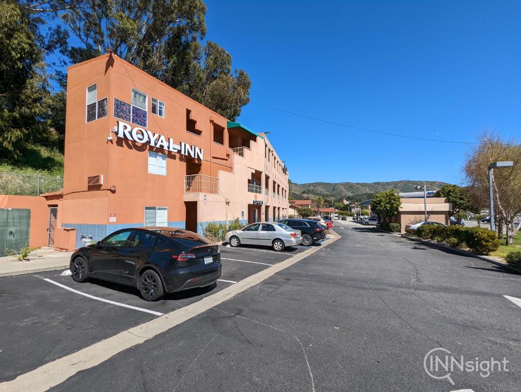 un estacionamiento con autos estacionados frente a un edificio en Royal Inn en South San Francisco