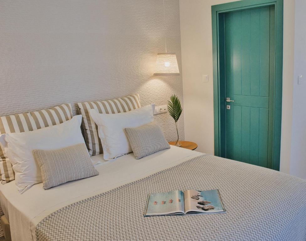 um quarto com uma cama com um livro em Aeolia suites em Cárpatos