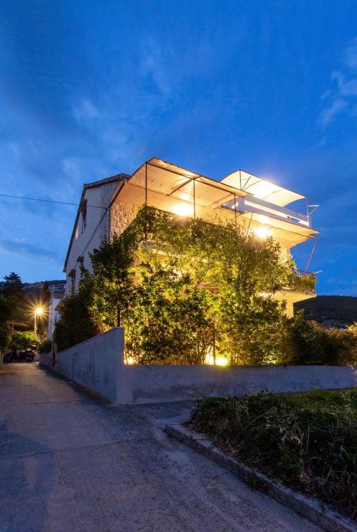 a building with ivy on the side of it at night at Villaina in Komiža