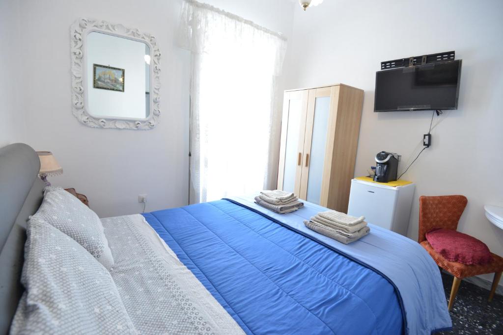a bedroom with a blue bed and a mirror at B&B CASAVACANZE CHIESA MADRE in Carovigno