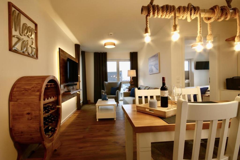 comedor y sala de estar con mesa y sillas en Hansehaus 12 - MEERZEIT, en Grömitz