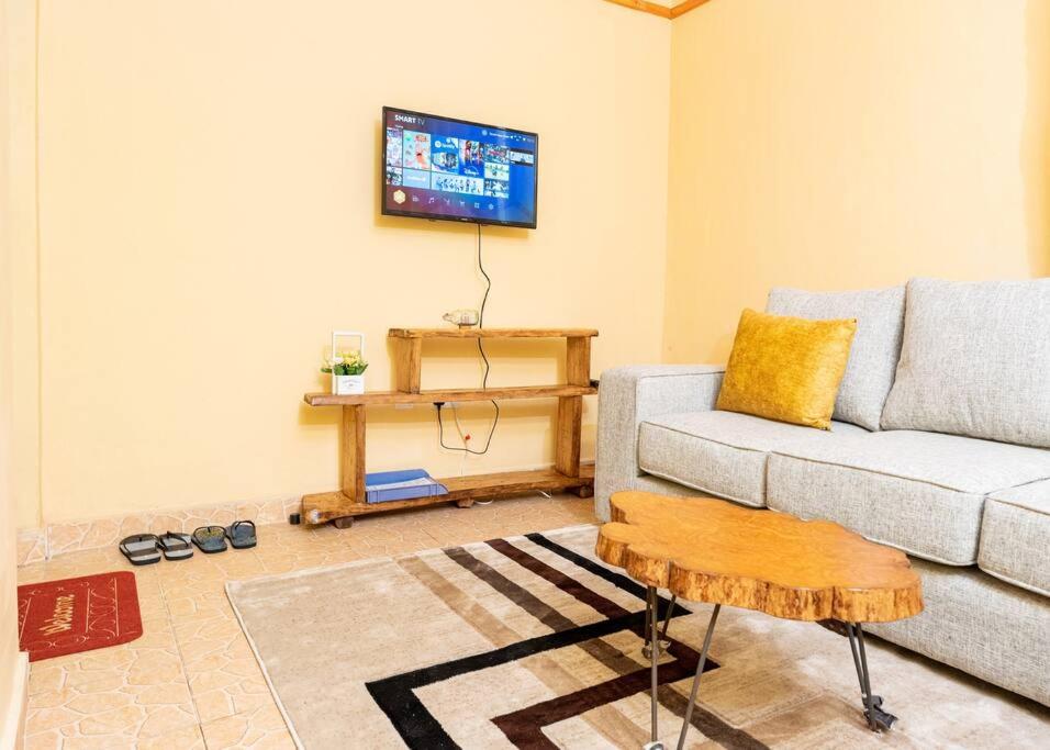 a living room with a couch and a tv at Repose Stay - Karen, 2 Bedroom, WiFi,Parking, CCTV in Nairobi