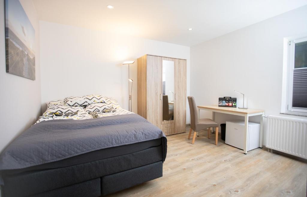 a bedroom with a bed and a desk with a chair at Chillzimmer in Duisburg