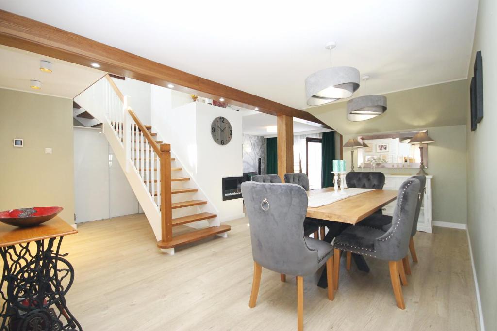 une salle à manger avec une table et des chaises et un escalier dans l'établissement Apartament Daisy, à Szczawno-Zdrój