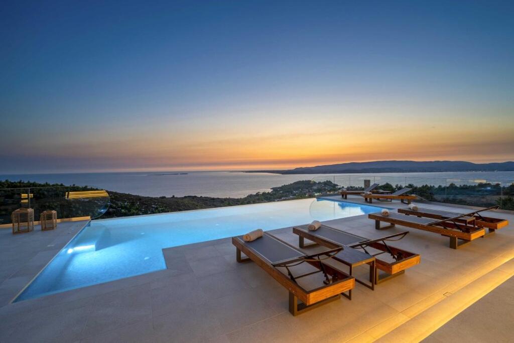 een zwembad op het dak van een huis met een zonsondergang bij Echos Villa in Argostoli