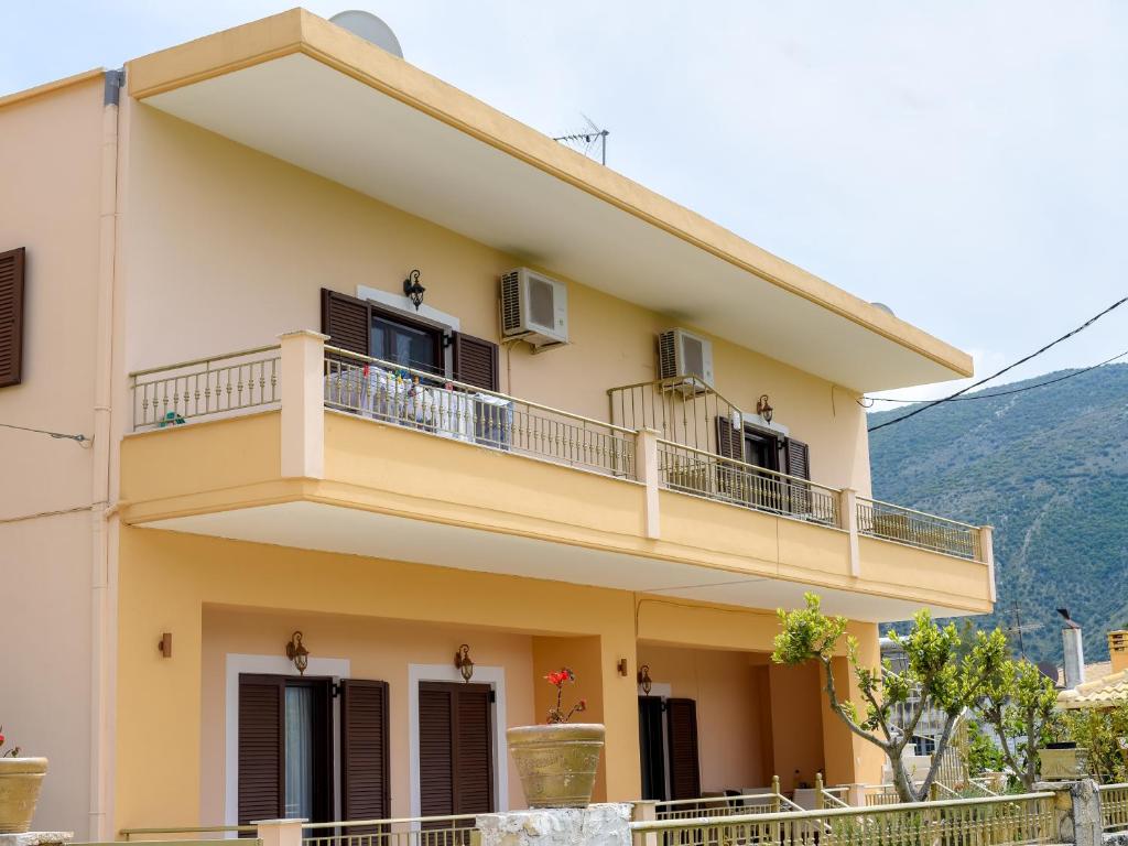une maison avec un balcon et des montagnes en arrière-plan dans l'établissement Tagkas Apartments, à Plataria